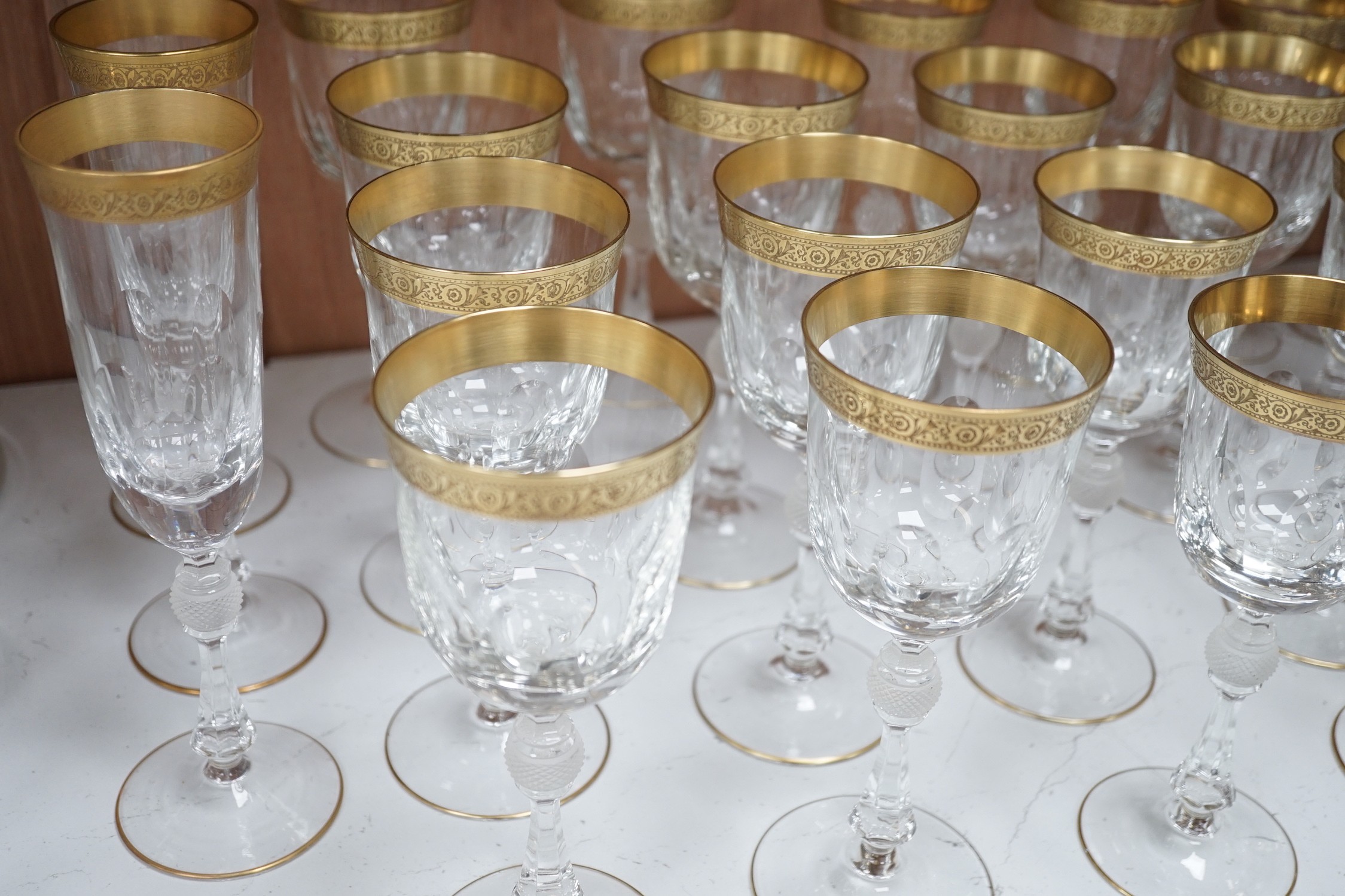 A Harrods retailed parcel gilt and cut and moulded suite of drinking glasses, two decanters and two carafes